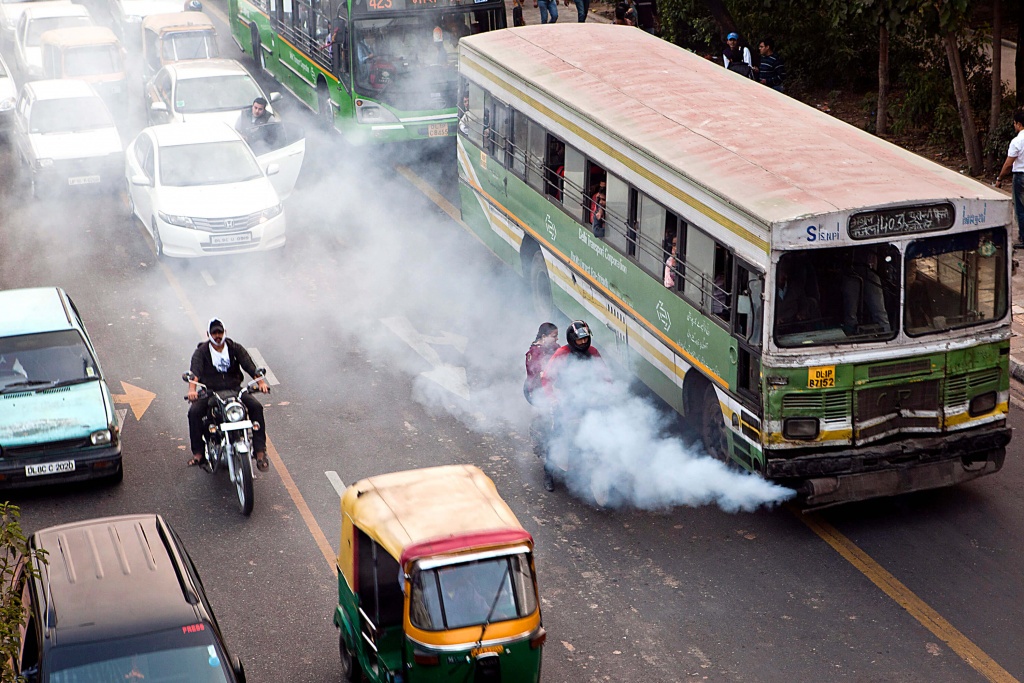 Pollution: An old public bus release excessive smoke onto a motorbike