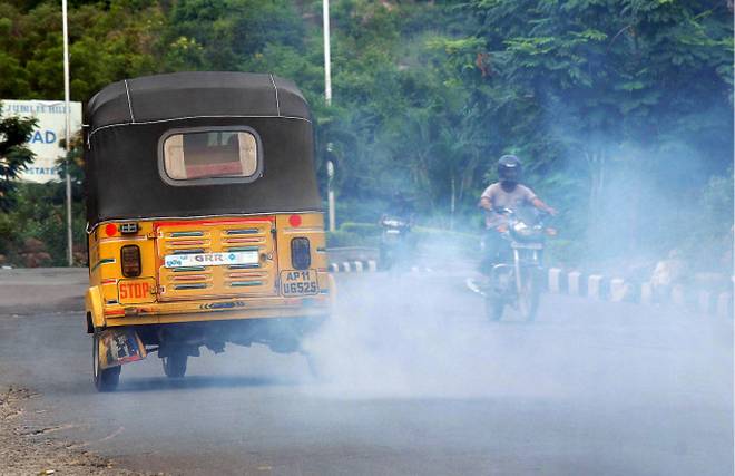 Pollution: an old auto rickshaw releases excessive smoke